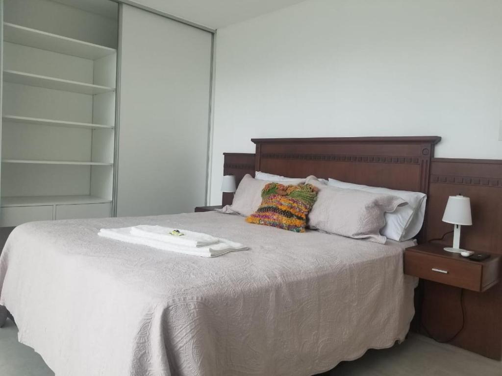 a bedroom with a large bed with a wooden headboard at Ayres de nieva dtos in San Salvador de Jujuy