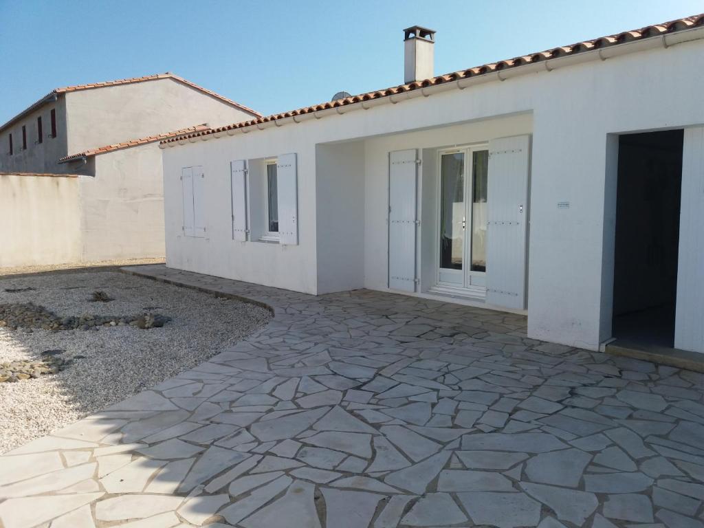 una casa bianca con un vialetto in pietra di Maison lumineuse à Ars en ré ad Ars-en-Ré