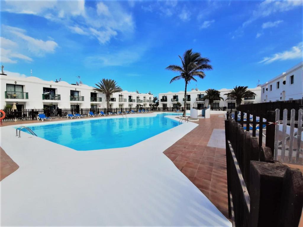 basen z palmą i budynkami w obiekcie Casa Gil Corralejo San Valentin by AHF w Corralejo