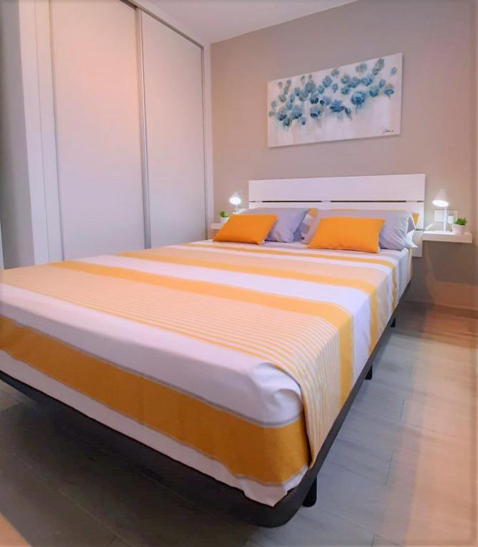 una camera da letto con un grande letto con cuscini arancioni di Casa Gil Corralejo San Valentin by AHF a Corralejo
