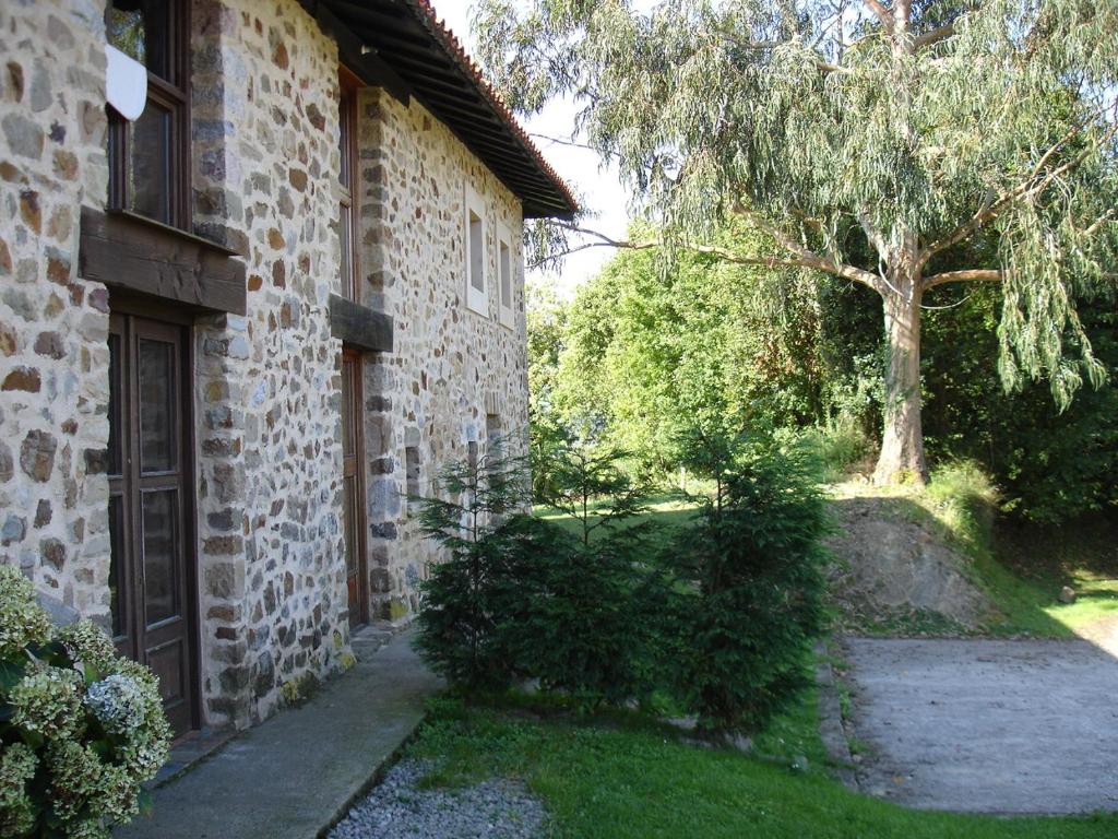 ein Backsteingebäude mit einer Tür und einem Baum in der Unterkunft Casa de Aldea Casina del Naranjo in Linares