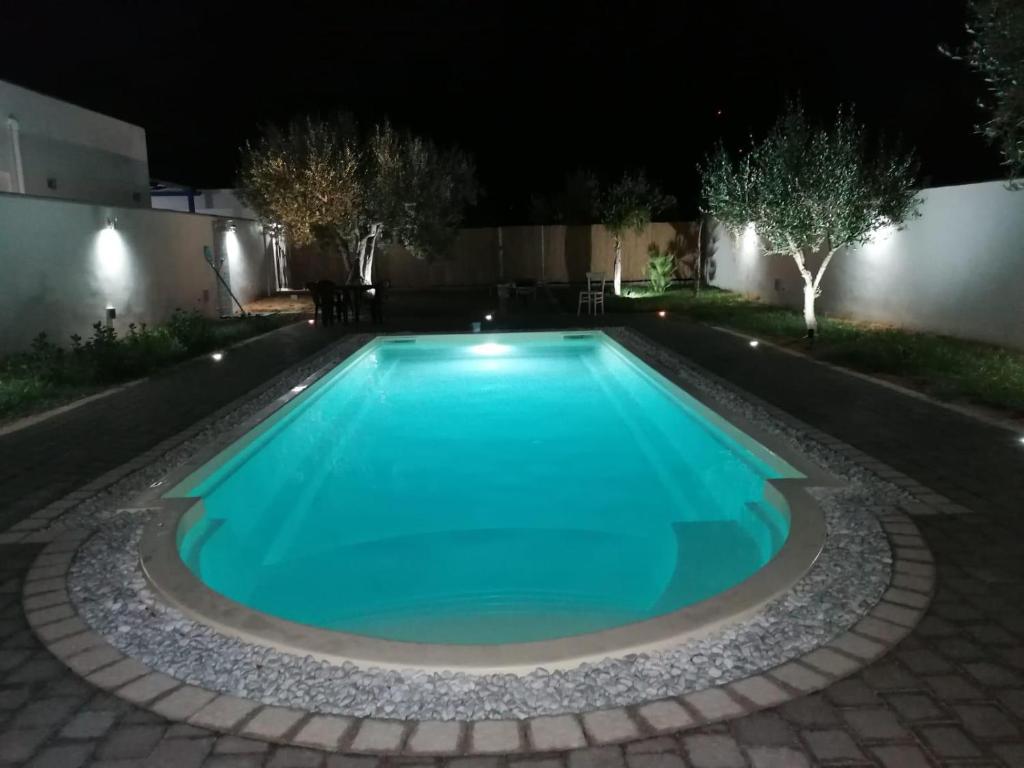 una piscina in un cortile di notte di B&B Santorini a Cinisi