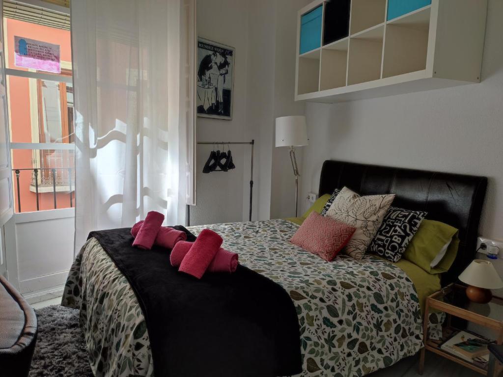 格拉納達的住宿－Principe A，一间卧室,床上有红色的弓