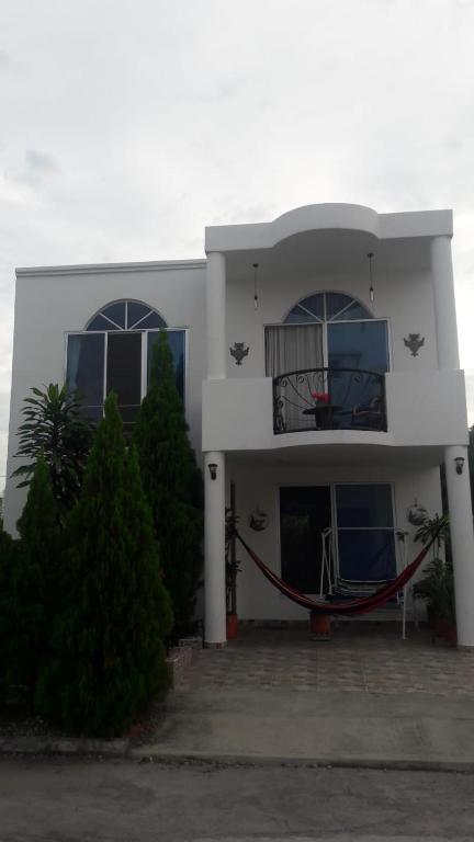 a white house with two windows and a balcony at Casa Veraneo Flandes con Piscina Privada in Flandes