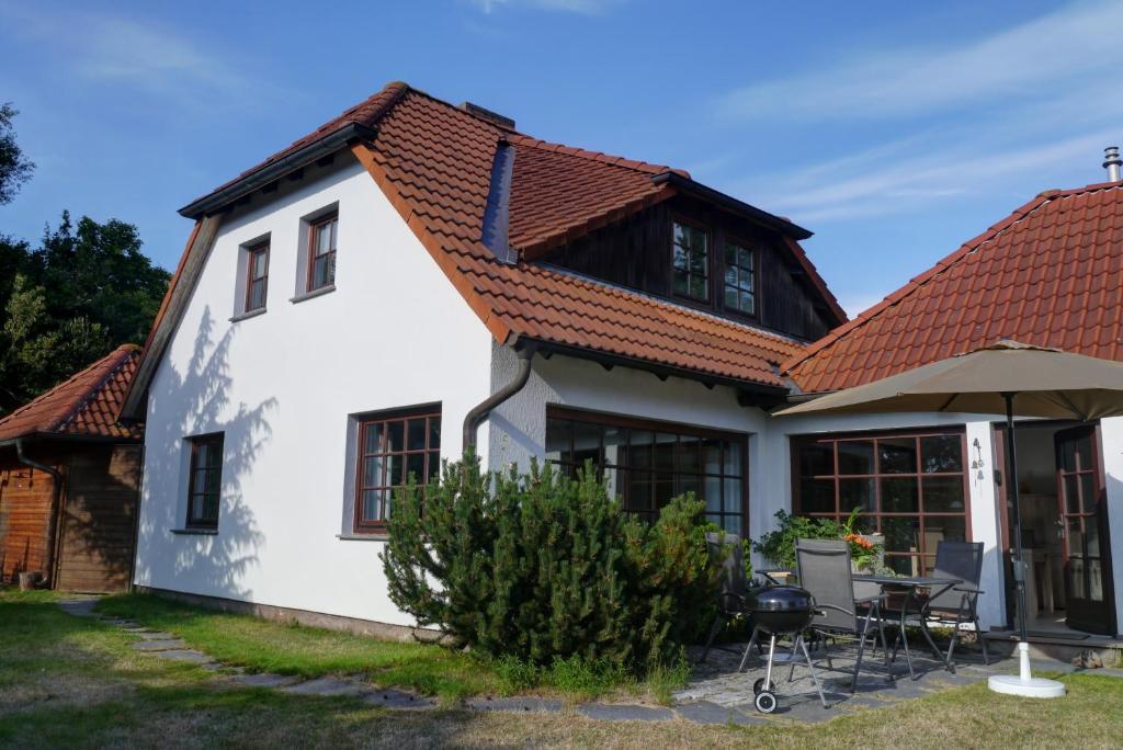 Biały dom z czerwonym dachem w obiekcie Haus Sonnenschein w Zingst