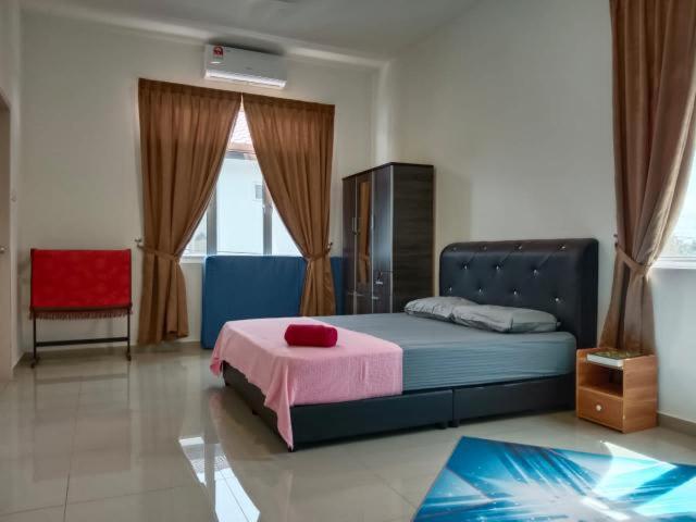 a bedroom with a blue bed and a red chair at D'Corner Homestay Kluang Perdana in Kluang