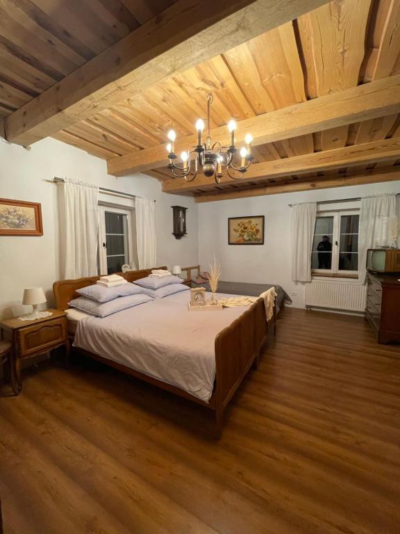 a bedroom with a large bed and a wooden ceiling at Chata na Zielonym Wzgórzu in Garcz