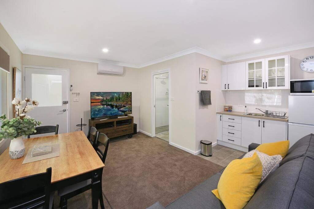 a living room with a couch and a table and a kitchen at Sur Le Mont - Blackheath - Studio Apartment in Blackheath
