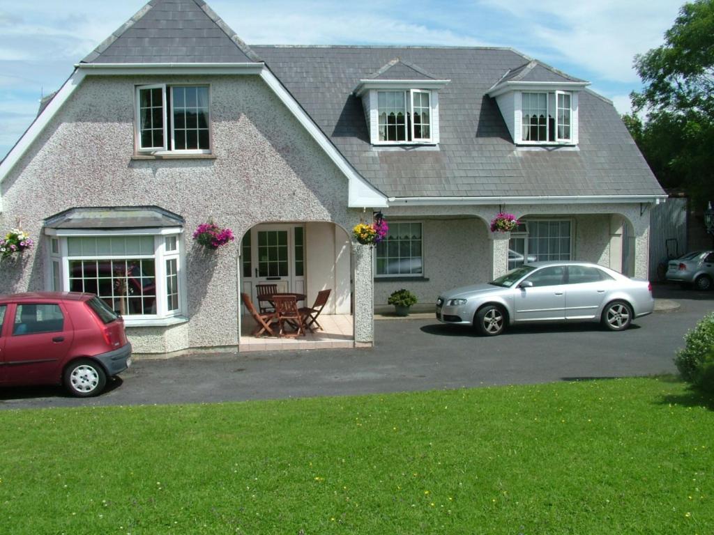 two cars parked in front of a house at Quarry Ridge B&B in Carlow