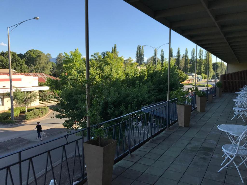 麦提福特Myrtleford Hotel的阳台配有桌椅和树木。