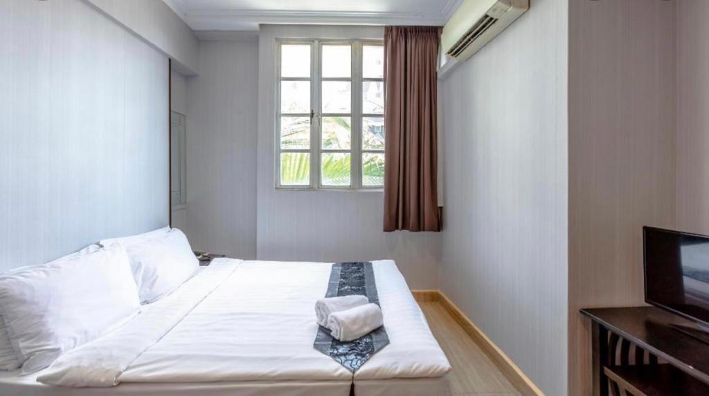 Hotel Duke في سنغافورة: غرفة نوم صغيرة بها سرير ونافذة