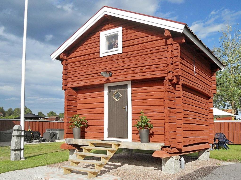 a small red cabin with a door and a porch at 4 person holiday home in RÄTTVIK-By Traum in Nedre Gärdsjö