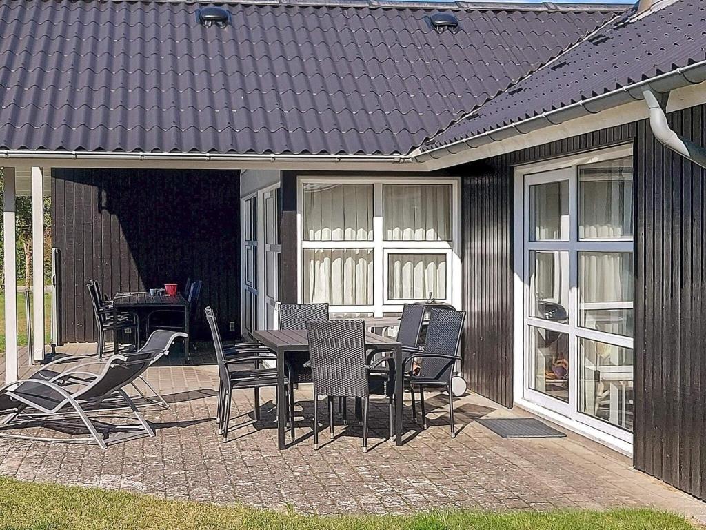 Nørre HurupにあるFour-Bedroom Holiday home in Hadsund 26のパティオ(テーブル、椅子付)