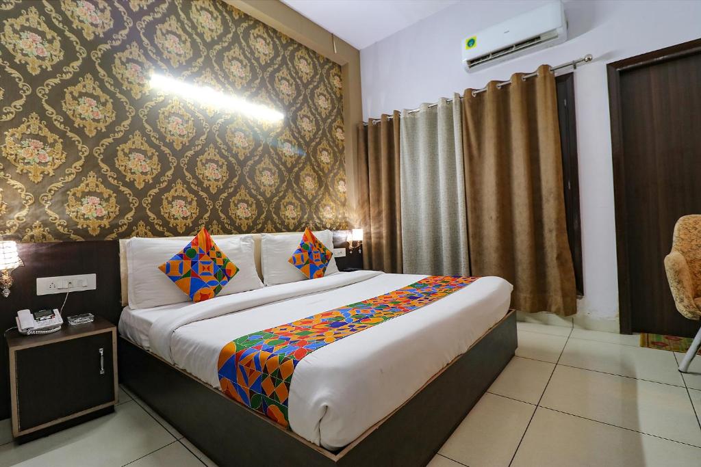a bedroom with a large bed with colorful pillows at FabHotel K9 in Ludhiana