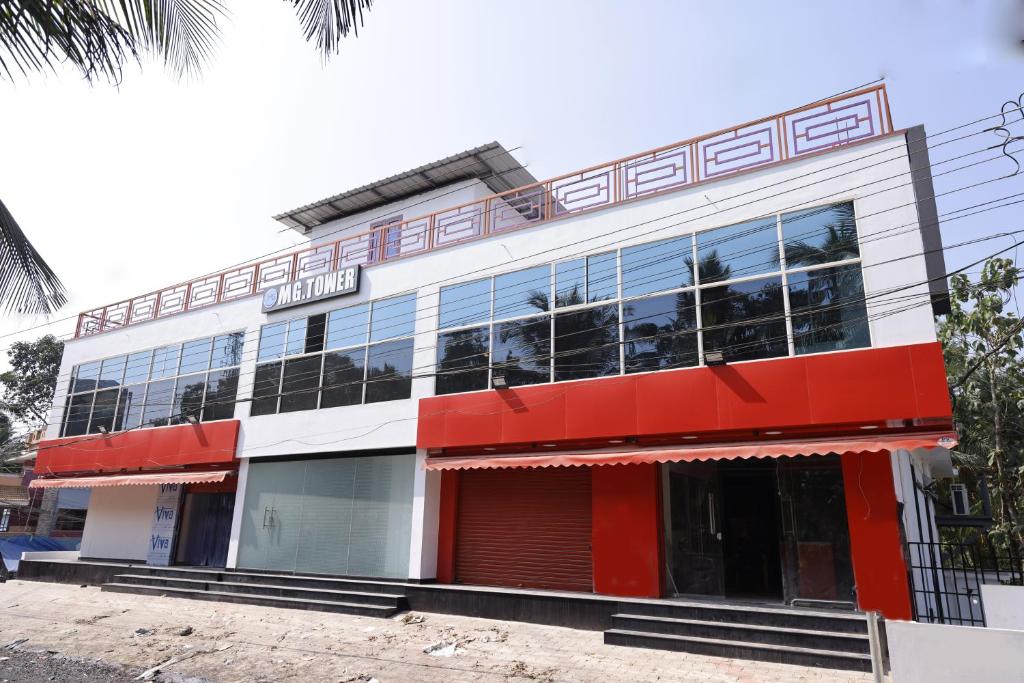 un edificio rojo y blanco con muchas ventanas en MG TOWER Hotel, en Trivandrum