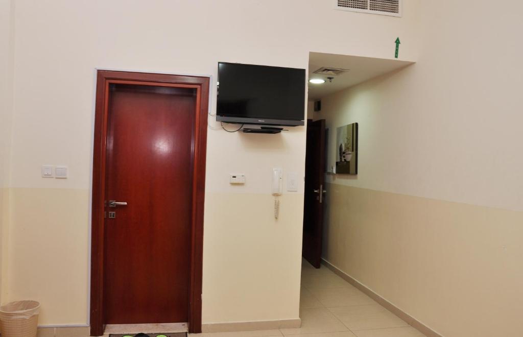 a room with a door and a tv on the wall at Africana Hotel in Dubai