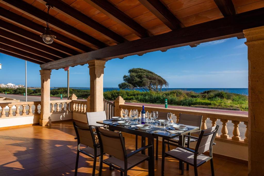 a table on a balcony with a view of the ocean at Casa vacacional Es Vell Marí in Sa Ràpita