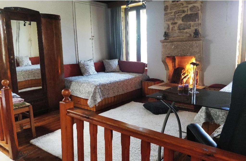 um quarto com uma lareira, uma cama e uma cadeira em The Traditional Greek House em Ioannina