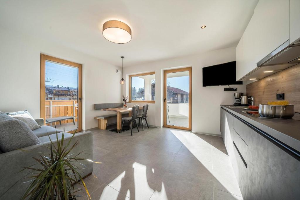 uma cozinha e sala de estar com um sofá e uma mesa em sunnig Apartment Sonnenaufgang em Vollan