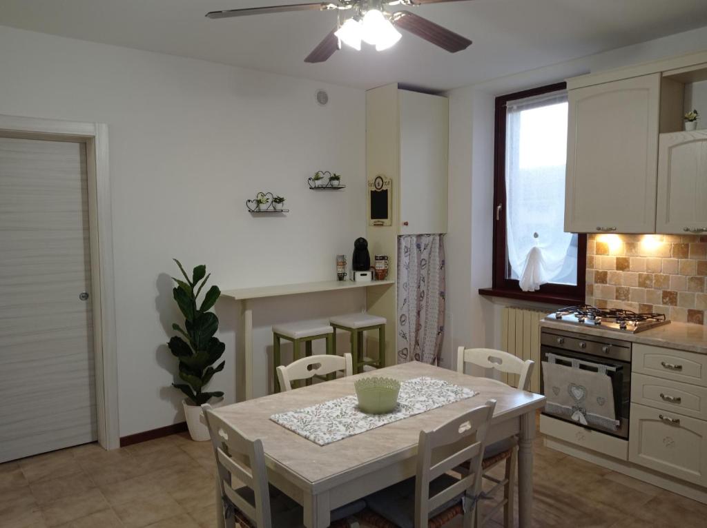 cocina y comedor con mesa y sillas en HOUSE PIAZZA VITTORIA, en Medole