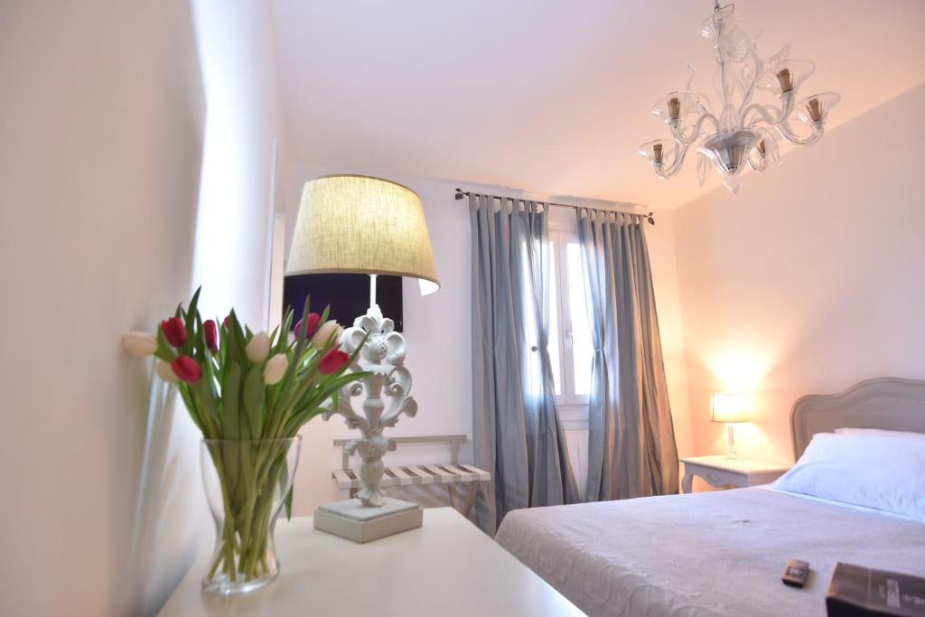 1 dormitorio con un jarrón de flores sobre una mesa en Palazzetto Barnaba en Venecia