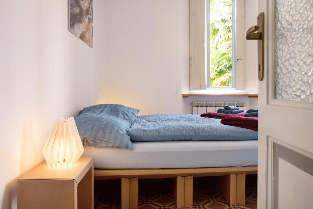 un letto in una stanza con finestra di Casa Corten Garden Lago Maggiore a Laveno-Mombello