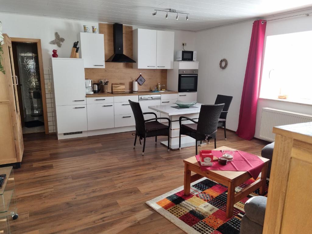 a kitchen and living room with a table and chairs at Ferienwohnung Norbert in Presseck