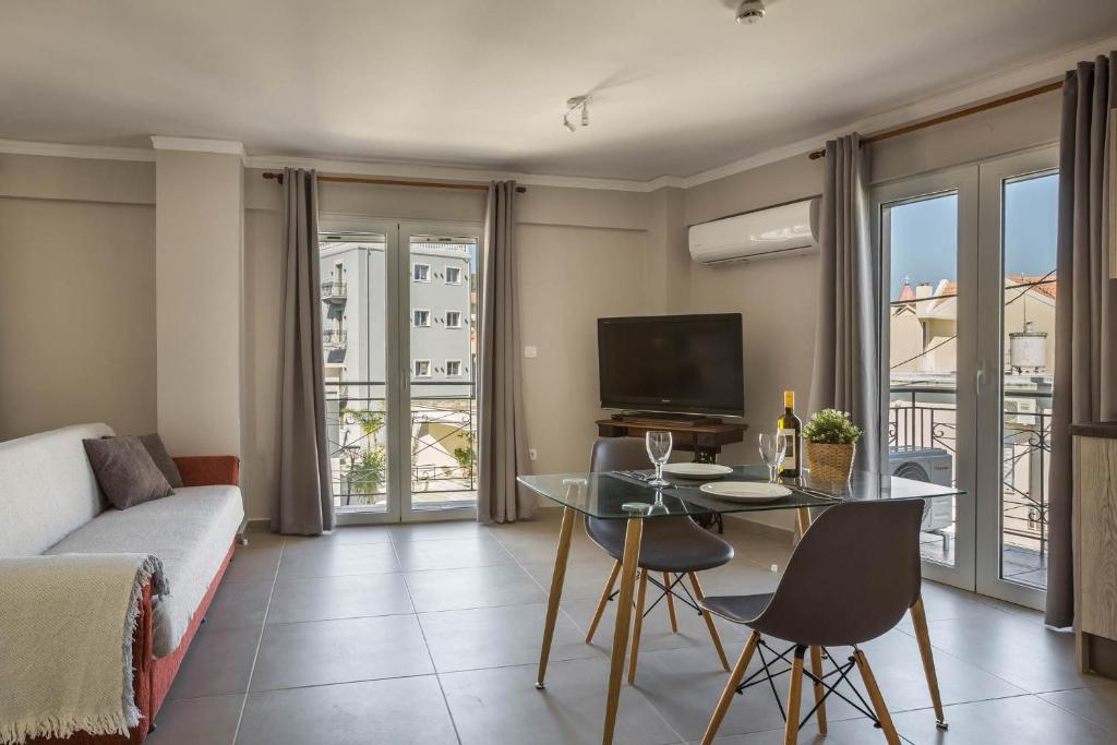 salon z kanapą i stołem z krzesłami w obiekcie Fidias city rooms w mieście Argostoli