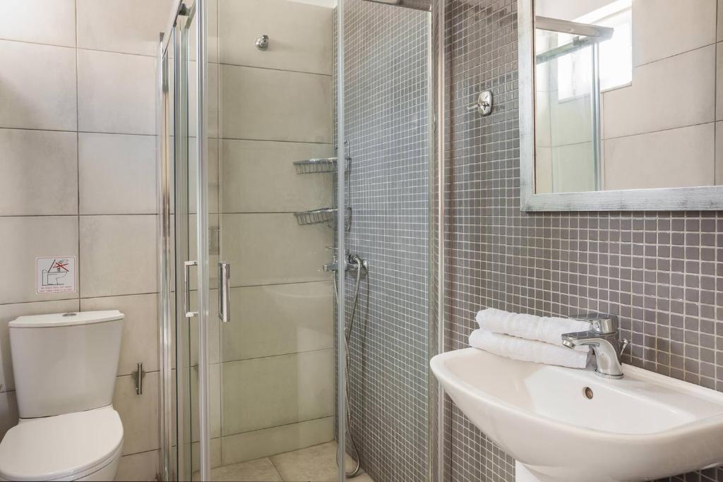 łazienka z toaletą, umywalką i prysznicem w obiekcie Fidias city rooms w mieście Argostoli