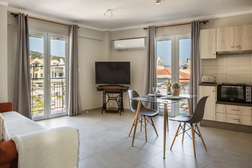 salon z telewizorem i stołem z krzesłami w obiekcie Fidias city rooms w mieście Argostoli