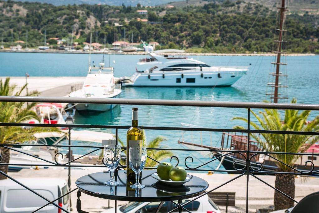 stół z butelką wina i kieliszkami na balkonie w obiekcie Fidias city rooms w mieście Argostoli
