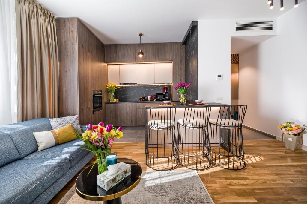 a living room with a blue couch and a kitchen at Bucharest Luxury Apartments in Bucharest