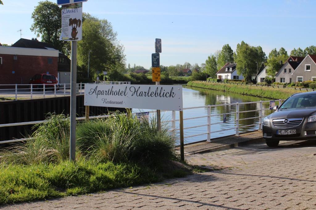 una señal en el lado de una carretera junto a un río en Aparthotel-Harleblick, en Carolinensiel