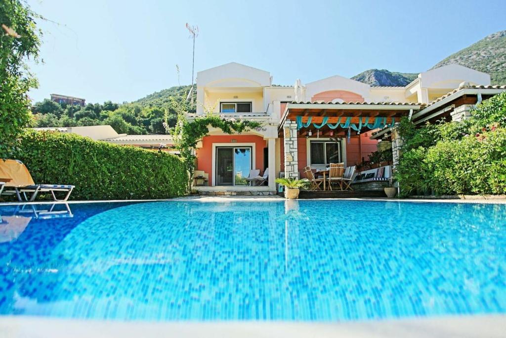 a swimming pool in front of a house at Beach Villa Blue by PosarelliVillas in Barbati