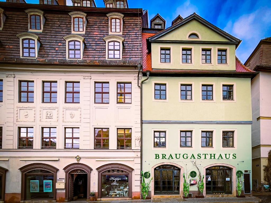 un gran edificio blanco con un cartel. en Braugasthaus, en Naumburg