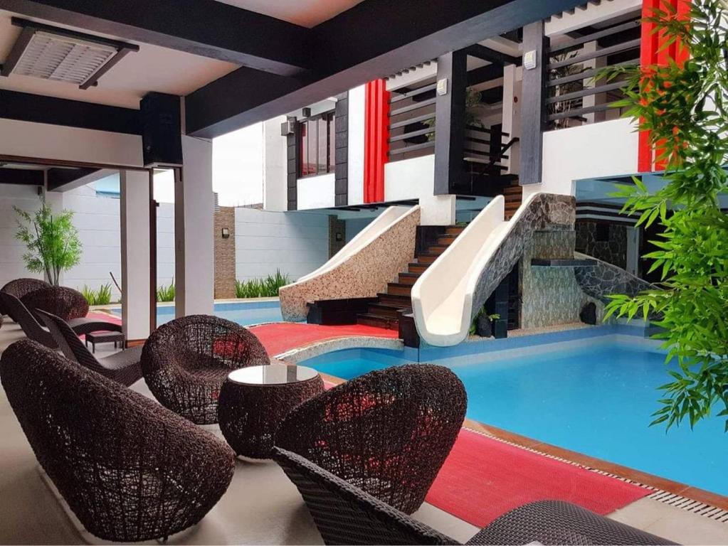eine Terrasse mit Stühlen und einem Pool in der Unterkunft Casa Demetria Duplex Hot Spring Resort Laguna in Pansol