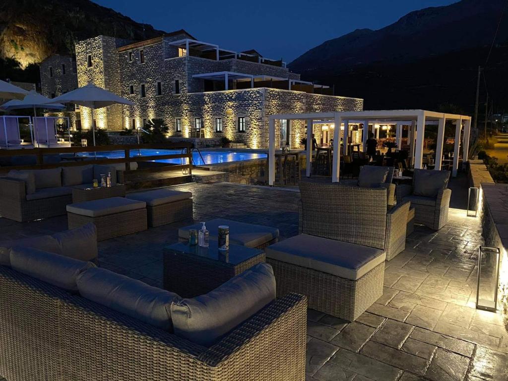 a outdoor patio with couches and tables at night at Itilo Traditional Hotel in Neon Oitilon