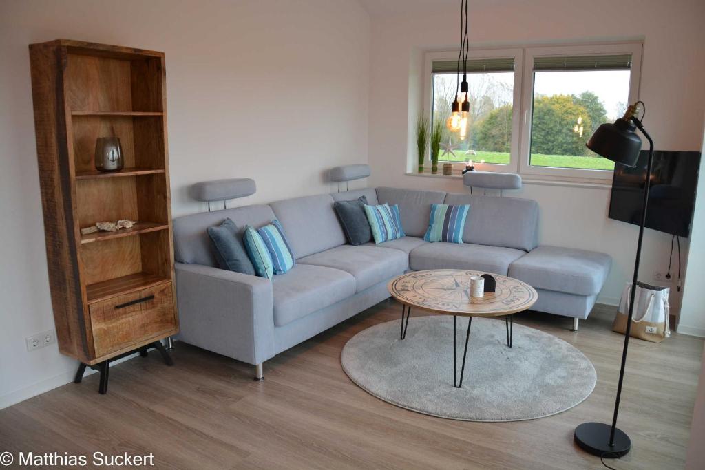 sala de estar con sofá azul y mesa en Fewo Captain Hook Haus Norderney, en Hooksiel