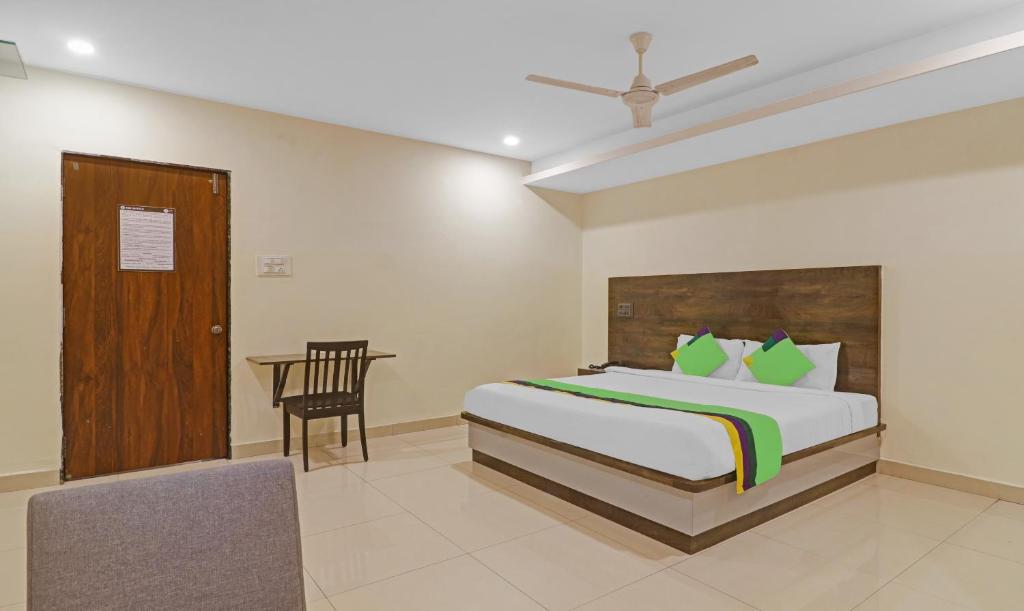 a bedroom with a bed and a chair and a desk at Treebo Trend Tee in Hyderabad