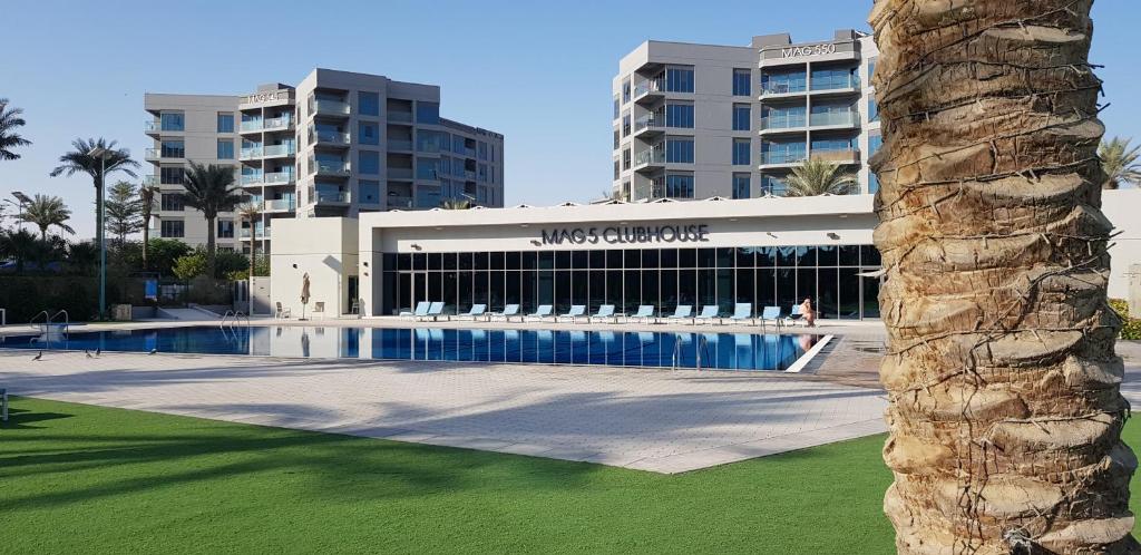 a building with a swimming pool in front of a building at Elegant and comfortably furnished 2BRH apartment in a quiet area! in Dubai