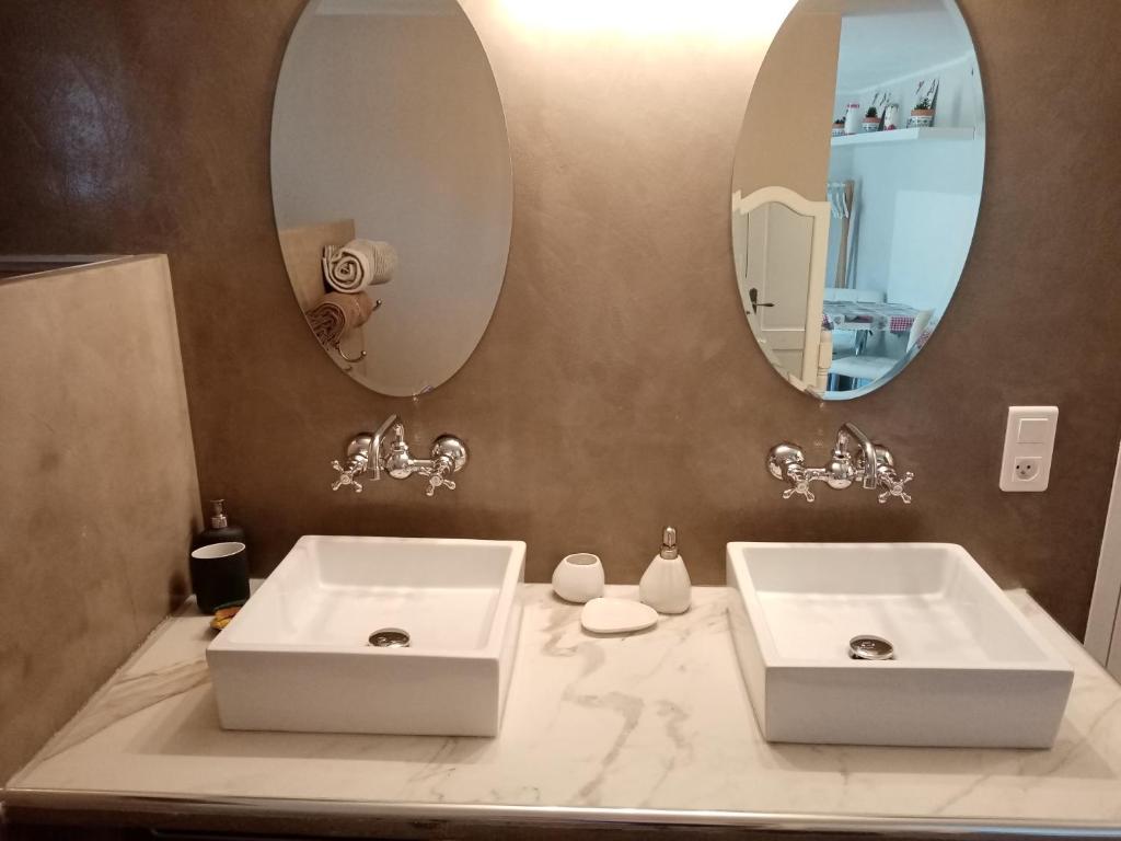 un baño con dos lavabos y dos espejos en Au Coeur du Luberon, en Cavaillon