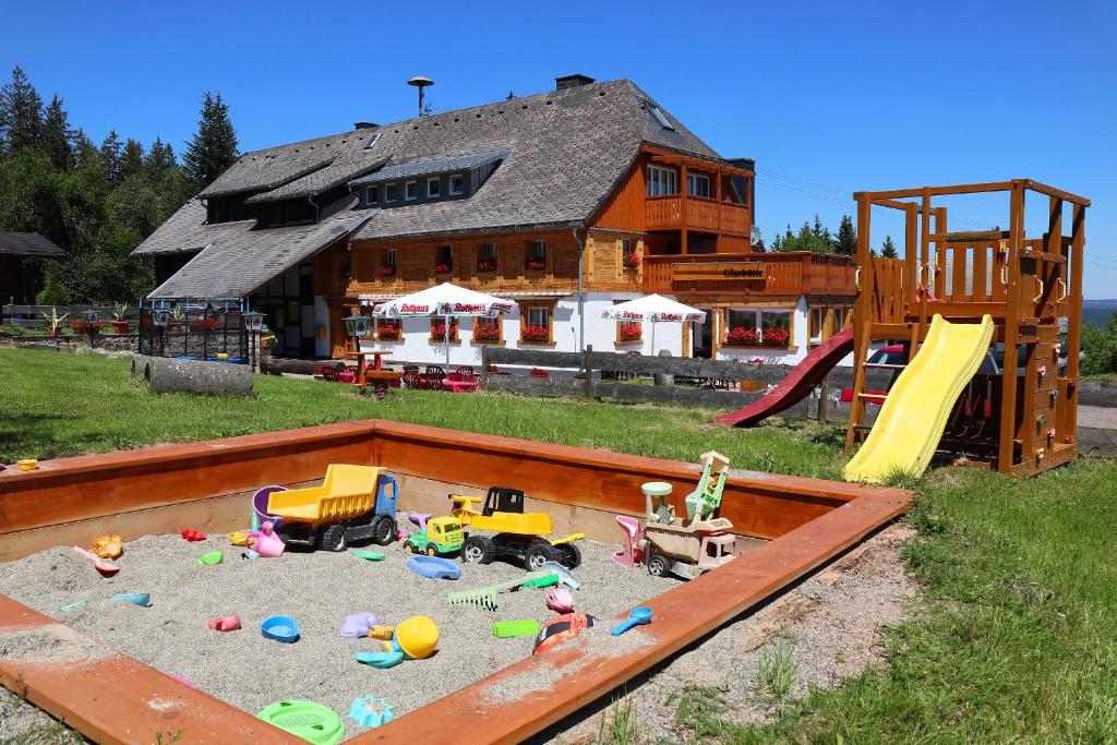 a sandbox with toys in it in front of a house at Ferienwohnung Waldrauschen in der Höhenpension Glashütte in Bonndorf im Schwarzwald