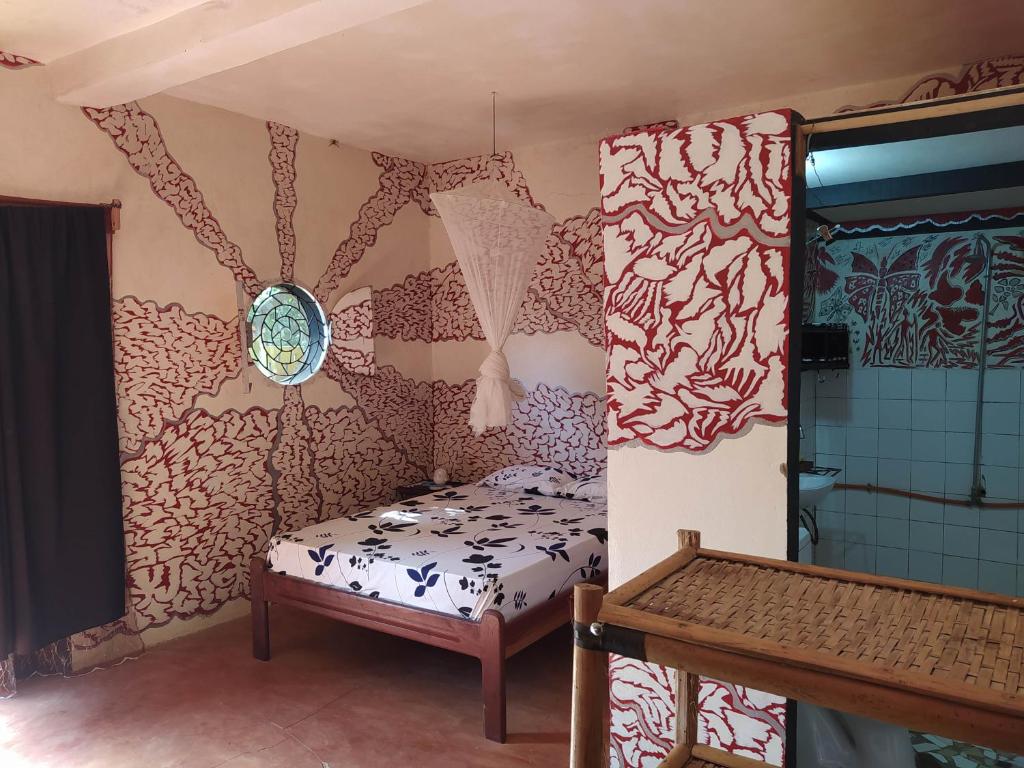 niewielka sypialnia z łóżkiem i oknem w obiekcie Chez Yaya - Grande Chambre w mieście Oussouye