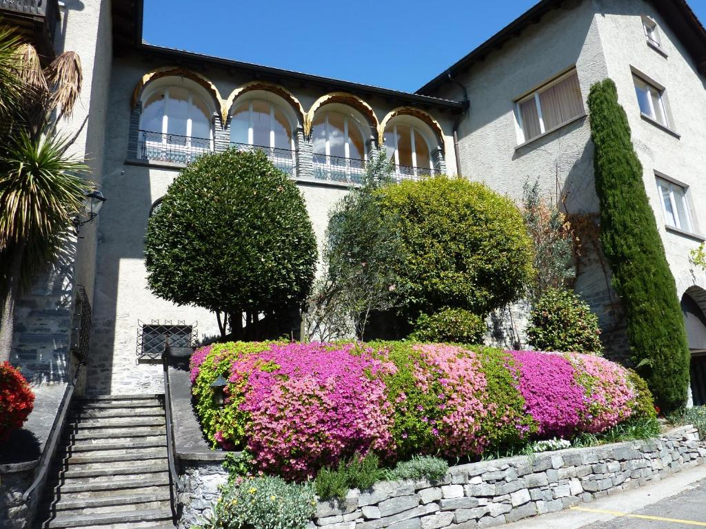 a building with a bunch of flowers in front of it at Suite Stays by Hotel La Perla in Ascona