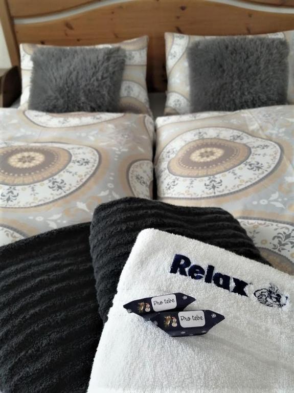 a bed with white and black sheets and pillows at Pension MAX in Pernink