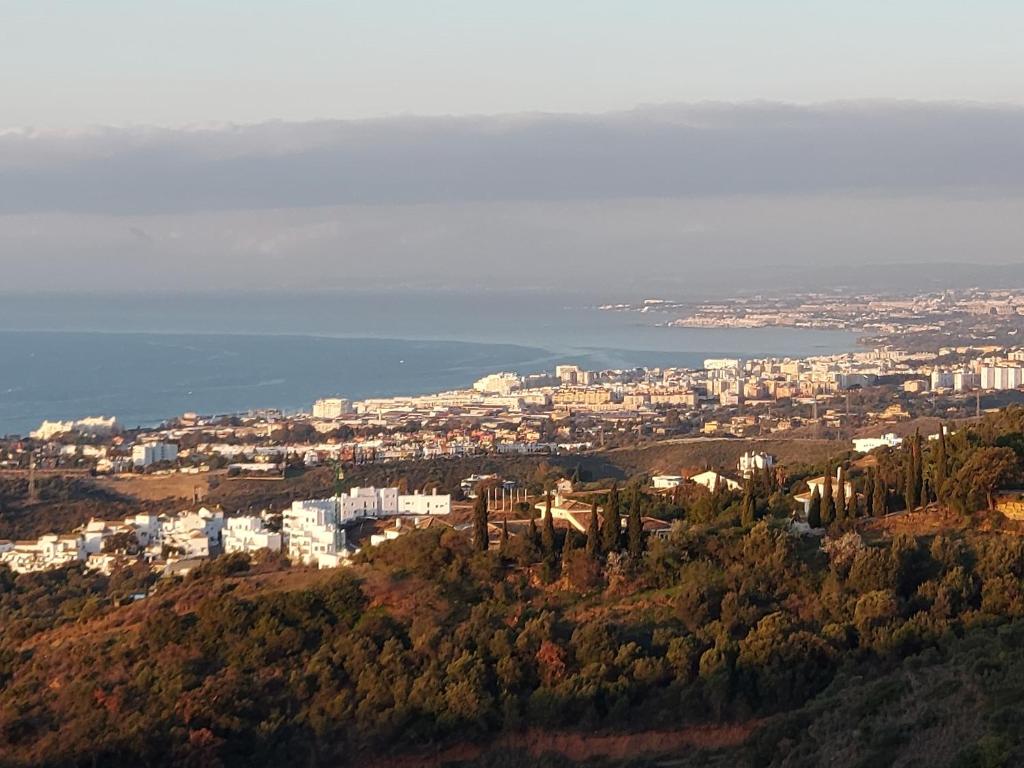 Blick auf eine Stadt von einem Hügel mit Bäumen in der Unterkunft VistaAlta in Marbella