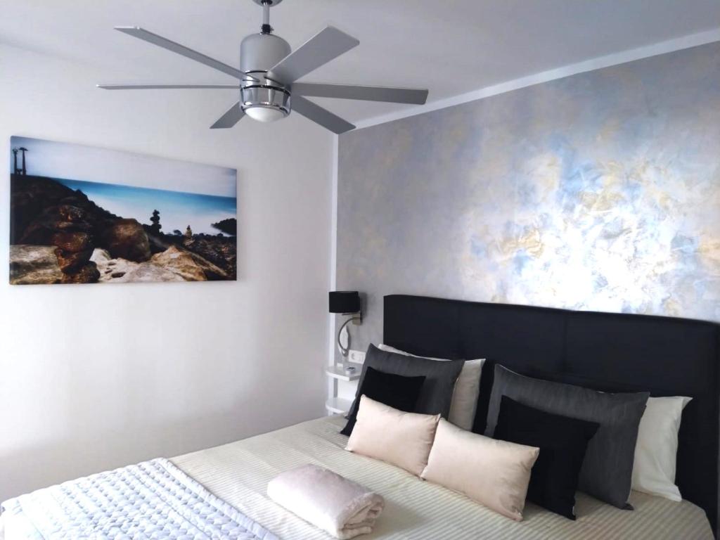 a bedroom with a bed with a ceiling fan at Apartment Portonovo Paraiso II - Sea View - swimming pool - good Wifi - Old Town in Puerto del Carmen