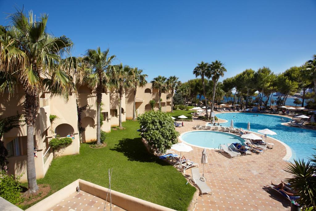 an aerial view of a resort with a pool and palm trees at Grupotel Santa Eulària & Spa - Adults Only in Santa Eularia des Riu