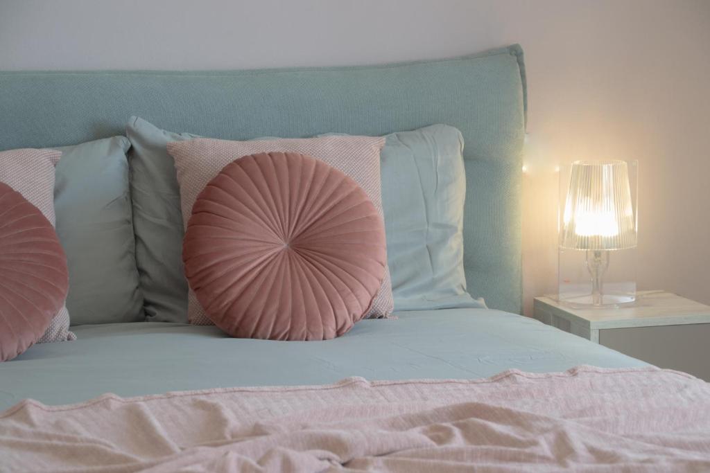 een bed met een roze kussen erop bij Casa Zeda - WelcHome in Verbania