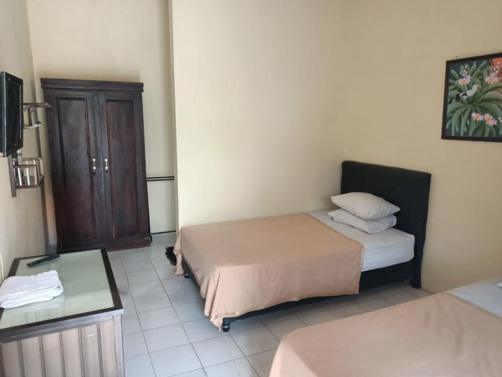Postel nebo postele na pokoji v ubytování RedDoorz at Hotel Nuansa Ngawi